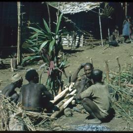 Men Sitting Around a Plant