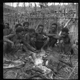 Group of Men Eating Pork