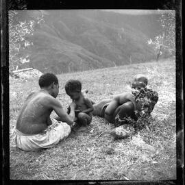 Woman, Man and Children Sitting on Mountainside