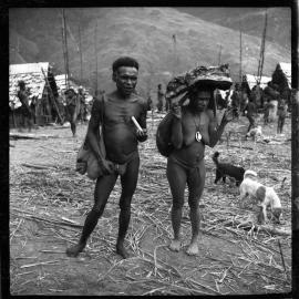 Man Standing with Woman Carrying Pork