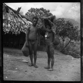 Man Standing with Woman Carrying Pork