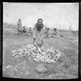 Man Standing with Pile of Vegetables