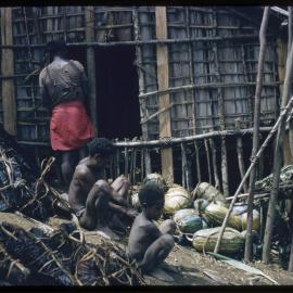 Men and Child Sitting Outside a Building
