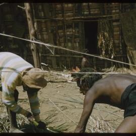 Two Men Collecting Sticks
