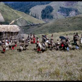 Crowd with Net Bags Walking Towards Village
