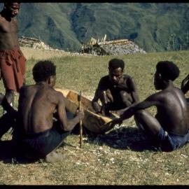 Men Carving a Log