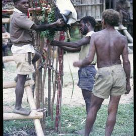 Men Preparing Elevated Platform in Village