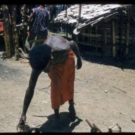 Man Picking up Food from Food Pile