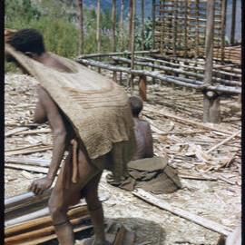 Woman with Net Bag By Partially Constructed Building