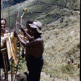 Men Standing Around a Stick Structure