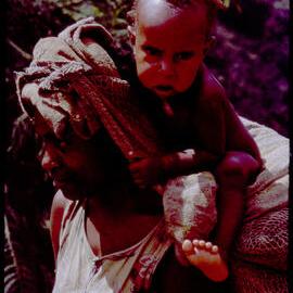 Woman Carrying a Net Bag and Baby