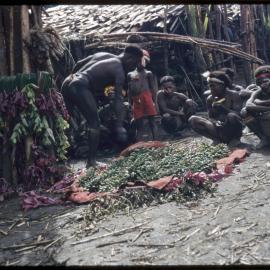 Group Sitting at the Base of a Food Pole