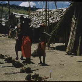 Men and Children Standing Beside Food Piles