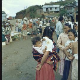 Woman Carrying Baby in a Market