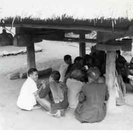 Group Sitting Beneath Wooden Structure on Stilts