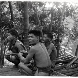 Three Men Sitting on Logs