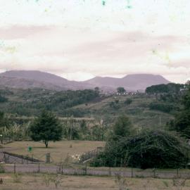 View Across Houses and Land, with Mountains in Background
