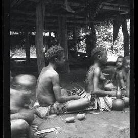 [Manum Island, New Guinea] A Woman Cutting Ornamental Scars on a Girl’s Back During her First Menstruation Rites