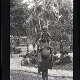 [Manum Island, New Guinea] A Woman of Boroi with her Child on her Back