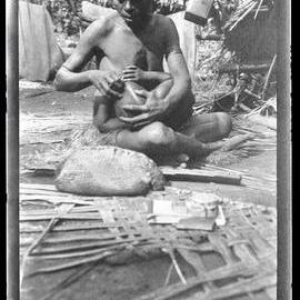 [Manum Island, New Guinea] Buburŋ Shaves the Head of her Son Abenaŋ, while he Sucks at her Breasts