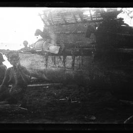 [Manum Island, New Guinea] The Blind Ona'a Waiting Beside the Canoe. Note the High Perapera of the Canoe with its Load
