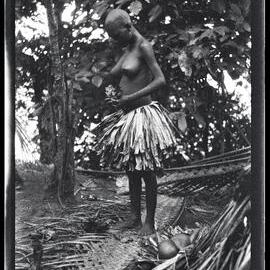 [Manum Island, New Guinea] Tsomoraua Annoints Herself with Special Leaves. The Baby is Lying on the Ground