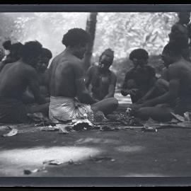 [Manum Island, New Guinea] Work Over. Some of the Tsokali Men Gather Round to Crack Galip Nuts Supplied by Mamboti
