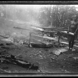 [Manum Island, New Guinea] The Beginning of the Cooking. Zeredo'i Standing Beside the 'Bed'