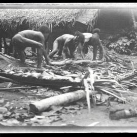 [Manum Island, New Guinea] Lifting one of the 'Cakes' of tapa'a 