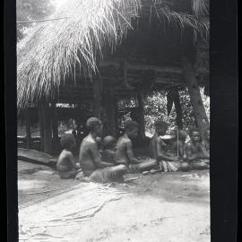 [Manum Island, New Guinea] lanai and her Maids-in-waiting. A Woman Cutting Orna­mental Scars on her