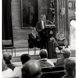 John Ward Answers Questions in the Great Hall Regarding Institutional Amalgamations and Consolidations